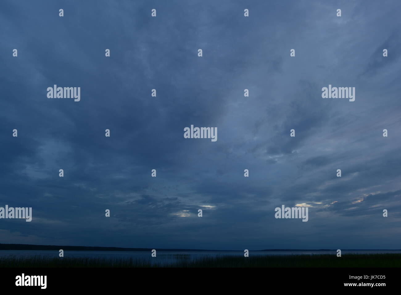 Bad weather cloudy sky dark blue above the lake Stock Photo