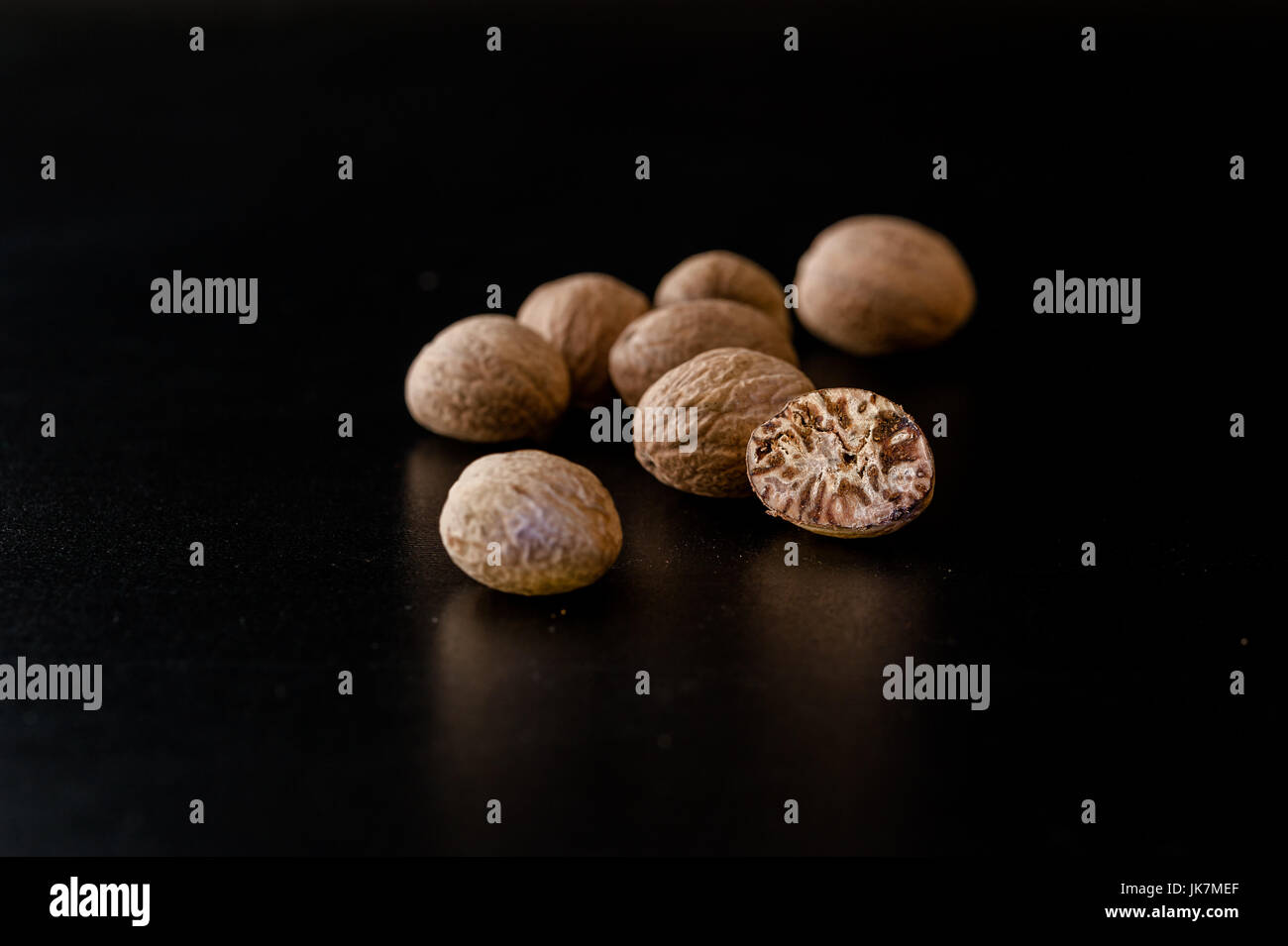 Nutmeg nuts and powder isolated on dark background Stock Photo Alamy