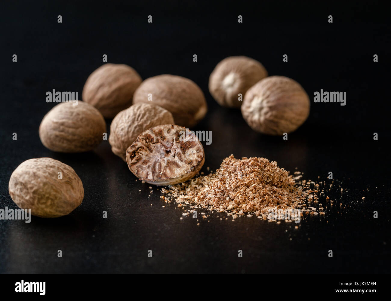 Nutmeg nuts and powder isolated on dark background Stock Photo Alamy