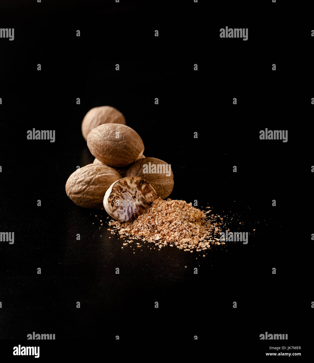 Nutmeg nuts and powder isolated on dark background Stock Photo Alamy