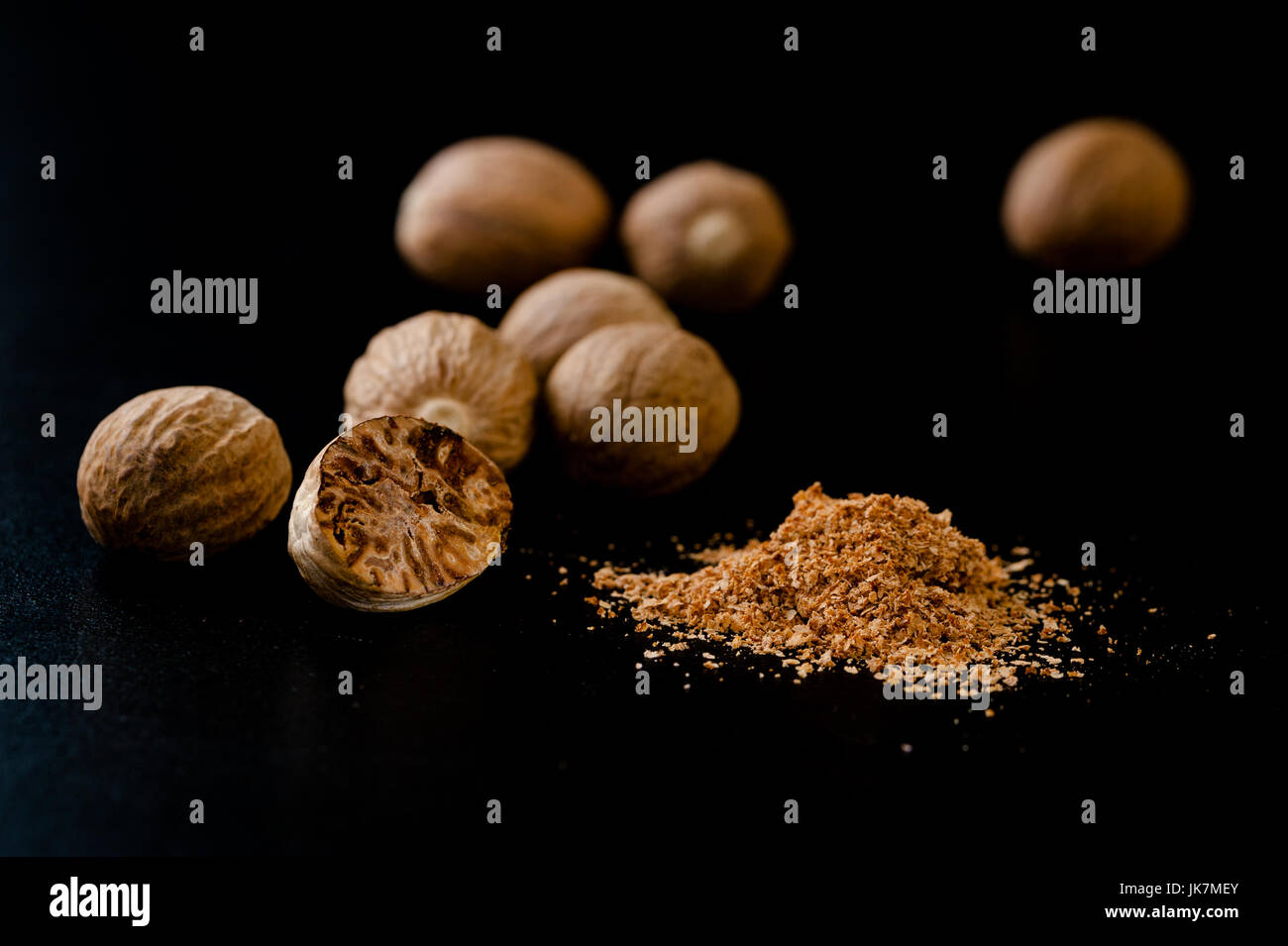 Nutmeg nuts and powder isolated on dark background Stock Photo Alamy