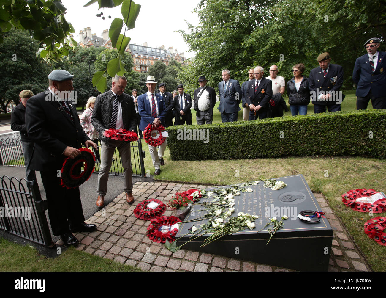 Mark Tipper (centre), whose 19-year-old brother Simon died in the blast, joins relatives of some of those killed in the IRA Hyde Park attack 35 years ago in laying a wreath after a march in Hyde Park, London, as part of a campaign to bring an accused bomber to justice. Stock Photo