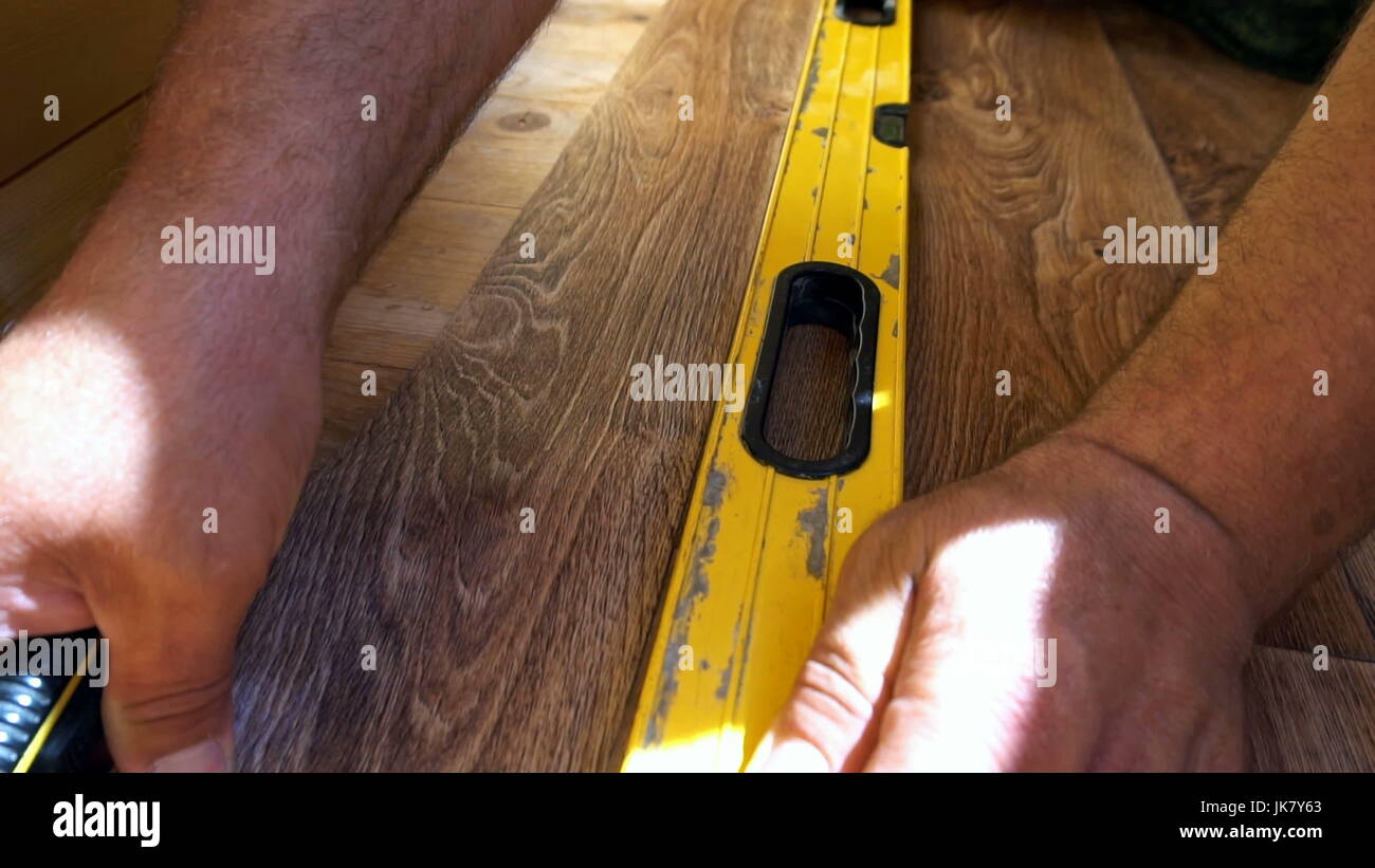 the worker cuts off the linoleum with a utility knife,fitting of