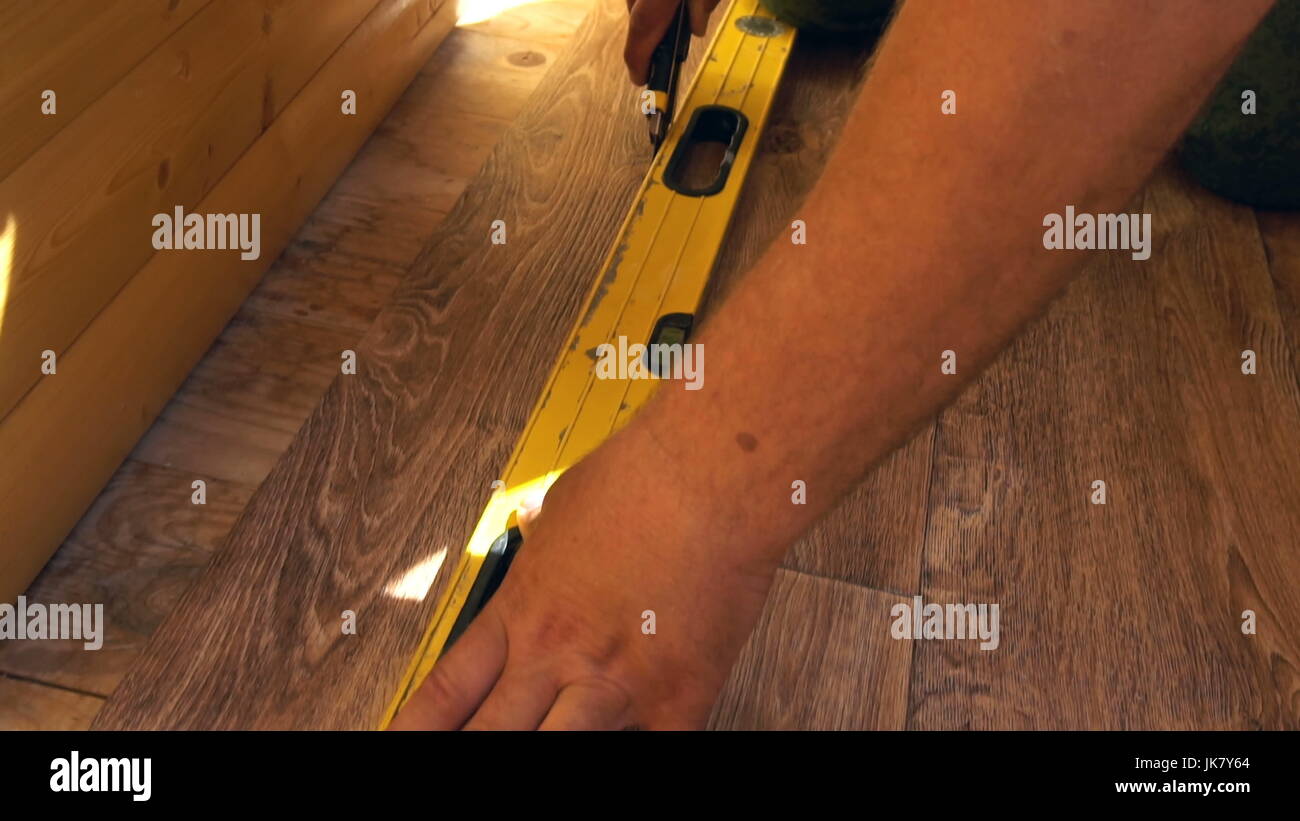 the worker cuts off the linoleum with a utility knife,fitting of