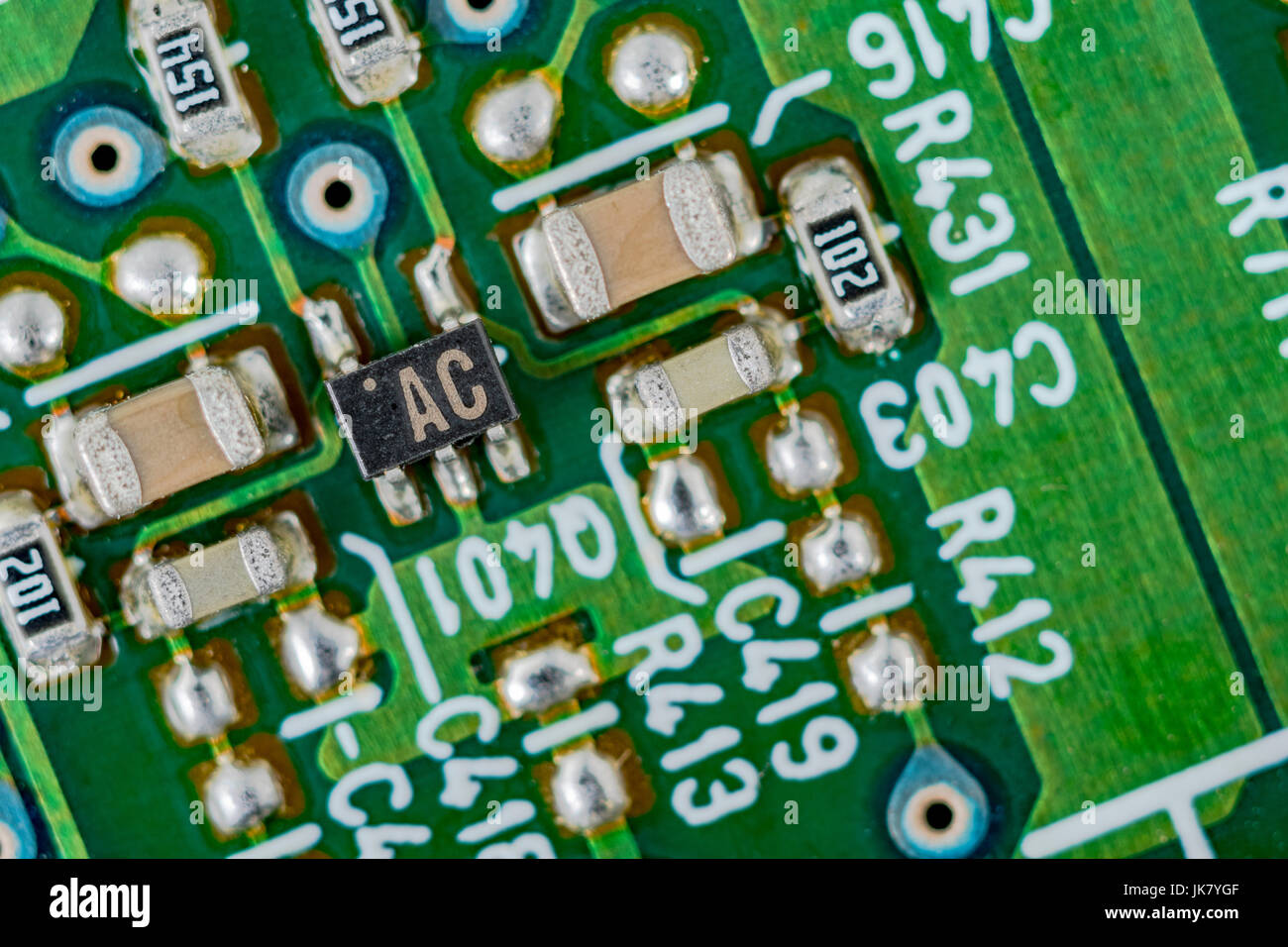 Surface mount technology (SMT) components on a green printed circuit board. Wiring inside computer, circuit close up, detail of a circuit board. Stock Photo