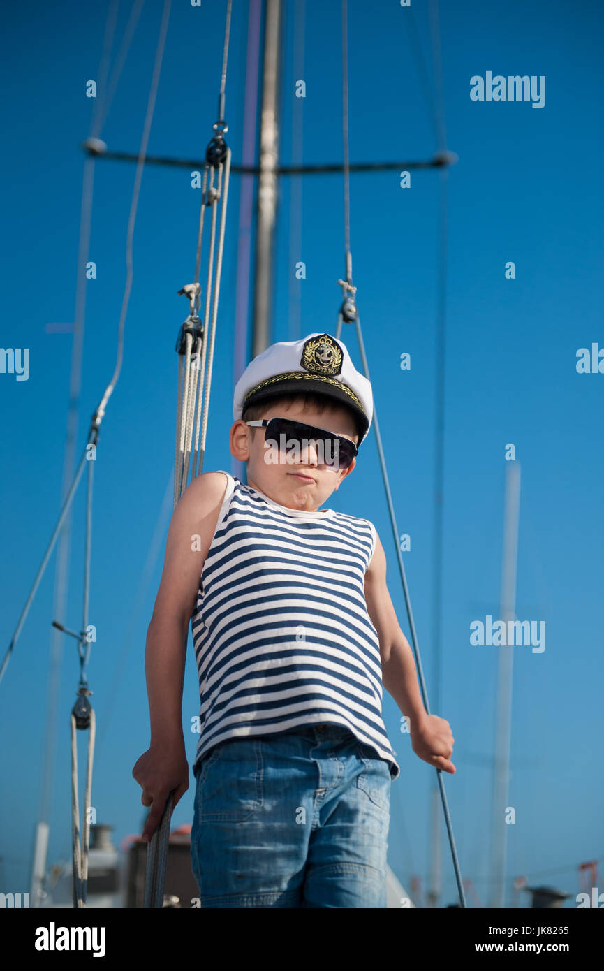 cool handsome little kid captain aboard luxury yacht on blue sky ...