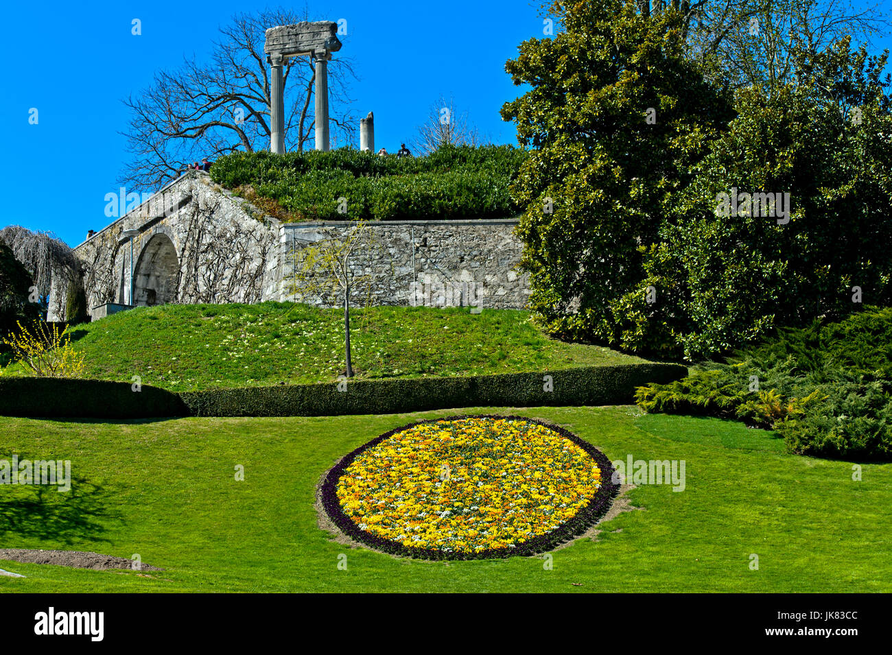Medallion of spring flowers in the park, roman columns behind, Nyon, Vaud, Switzerland Stock Photo