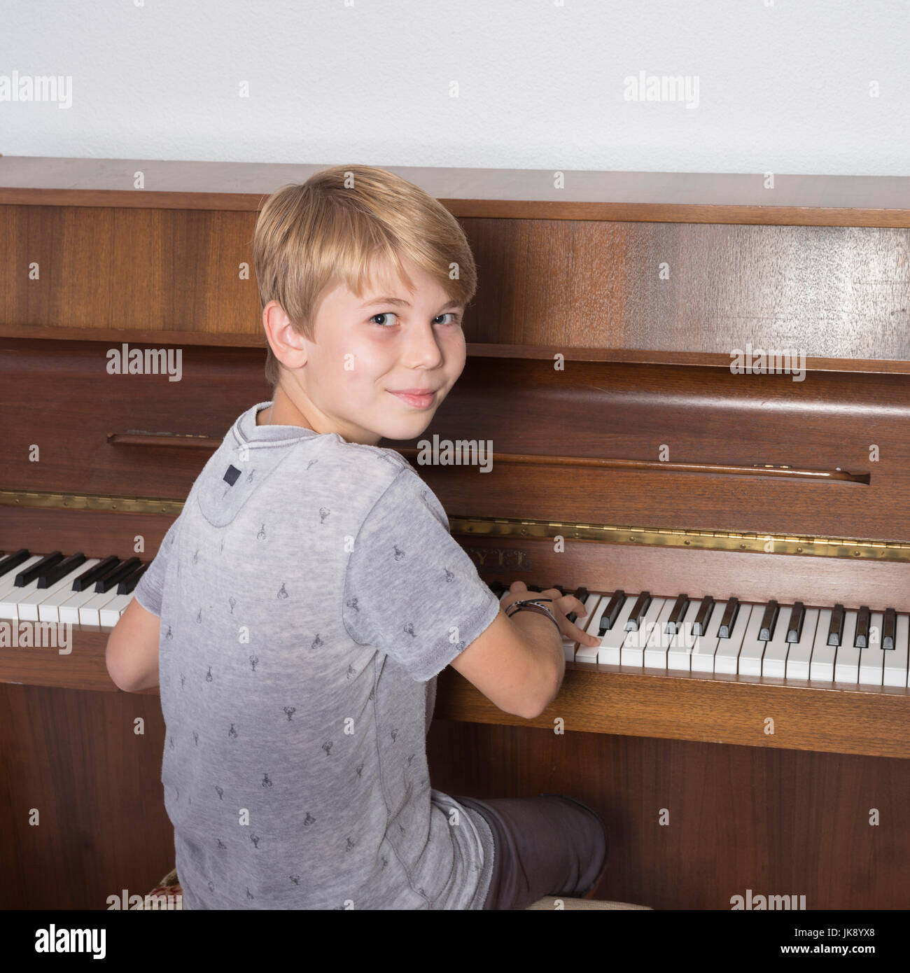 Blond boy playing piano hi-res stock photography and images - Alamy