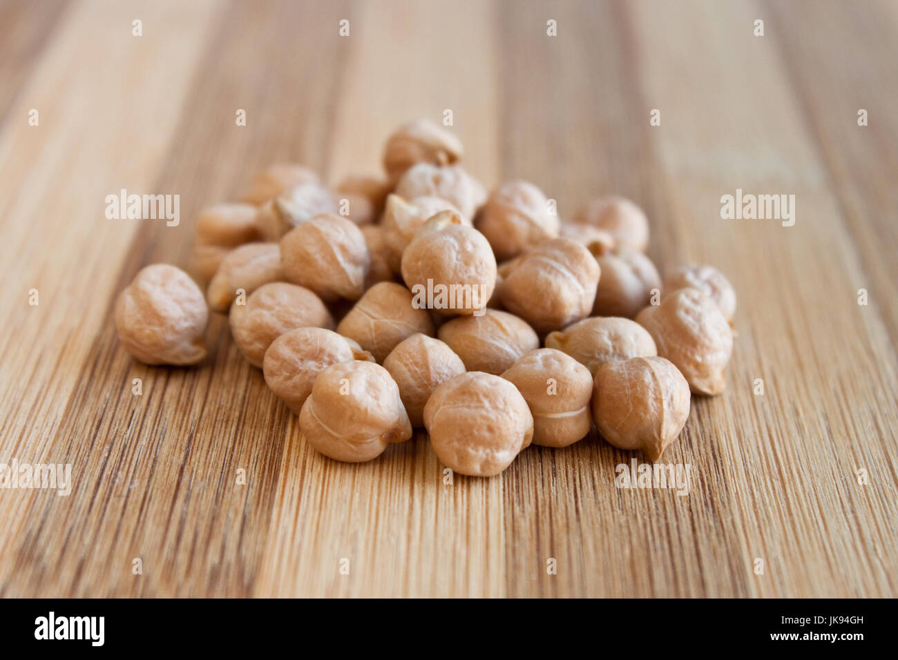 Heap of raw dried white chickpeas on a wooden table Stock Photo