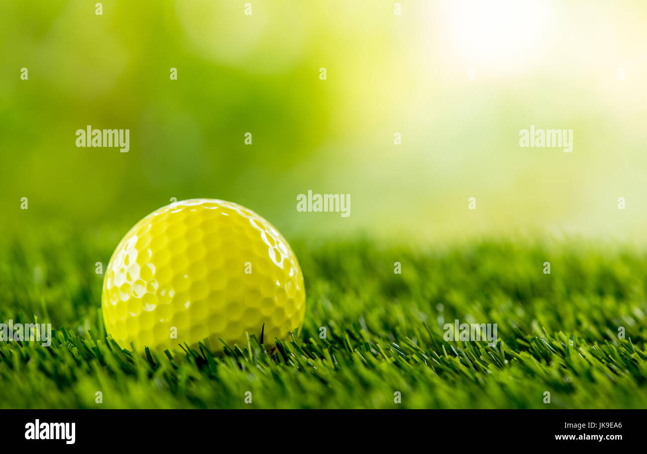 yellow golf ball on green field Stock Photo - Alamy