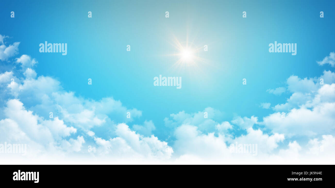Sunlight shining high in blue sky, above white clouds Stock Photo