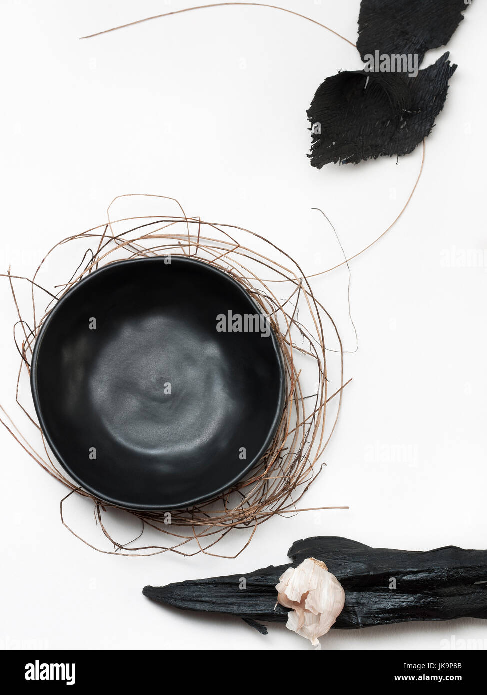 beautiful black dish on the bush or bird's nest and garlic art on white wooden background on white wooden background Stock Photo