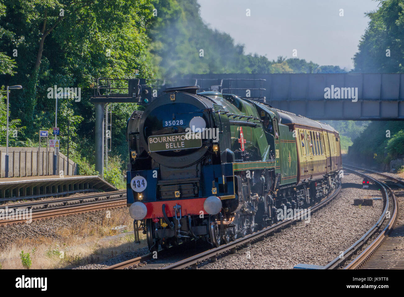 Clan Line. A Merchant Navy Class Steam  locomotive speeds through Farnborough Station , Hampshire on 5th July, 2017.  with The Bournemouth Belle repli Stock Photo