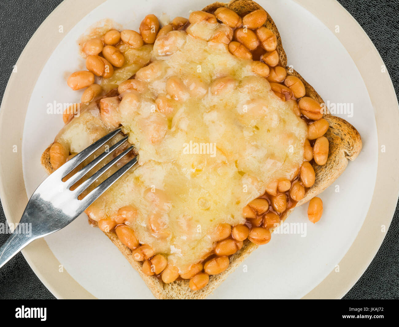 Baked Beans and Melted Cheese on Toast Against a Black Background Stock Photo Alamy