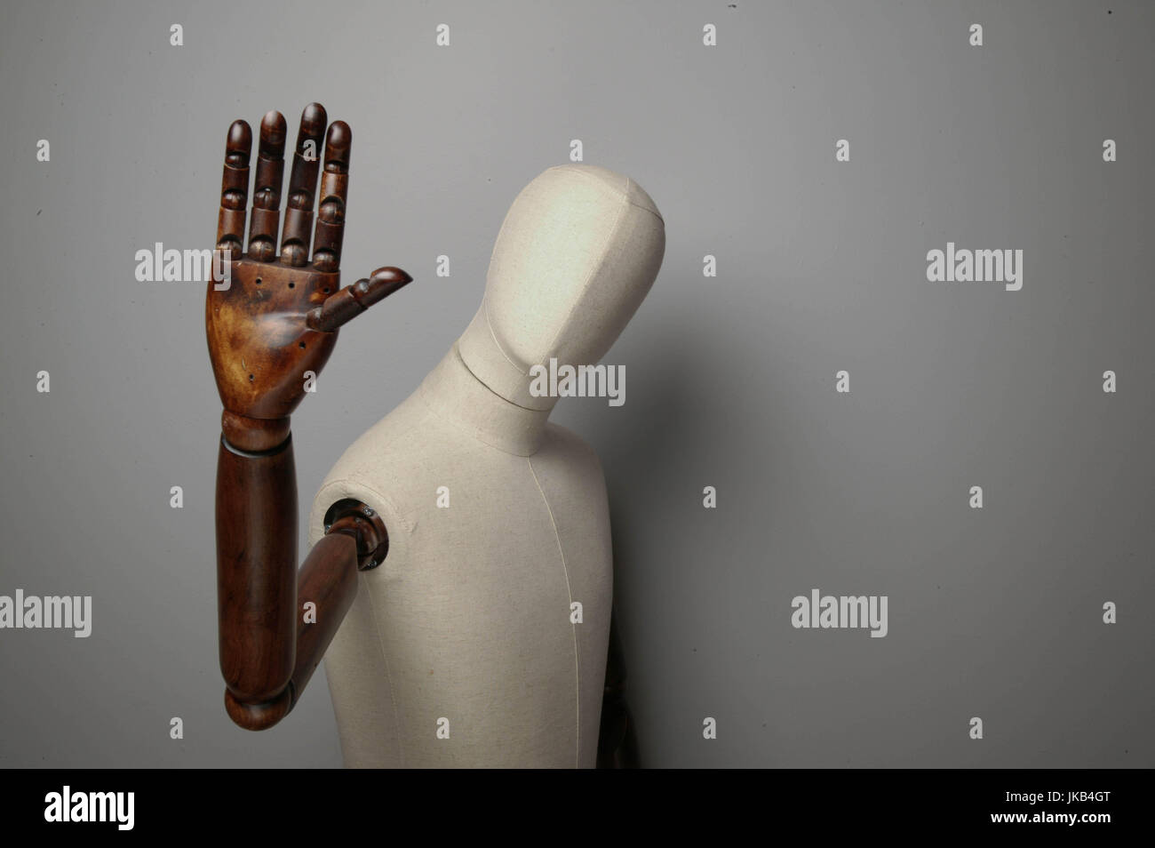 White mannequin with wooden arms waving towards the camera Stock Photo