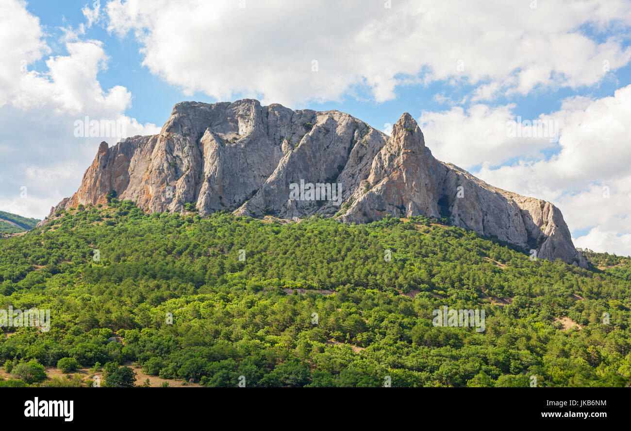 A majestic mountain towering over a valley covered with forests at the foot. Mount Parsuk-Kaya peninsula of Crimea Stock Photo