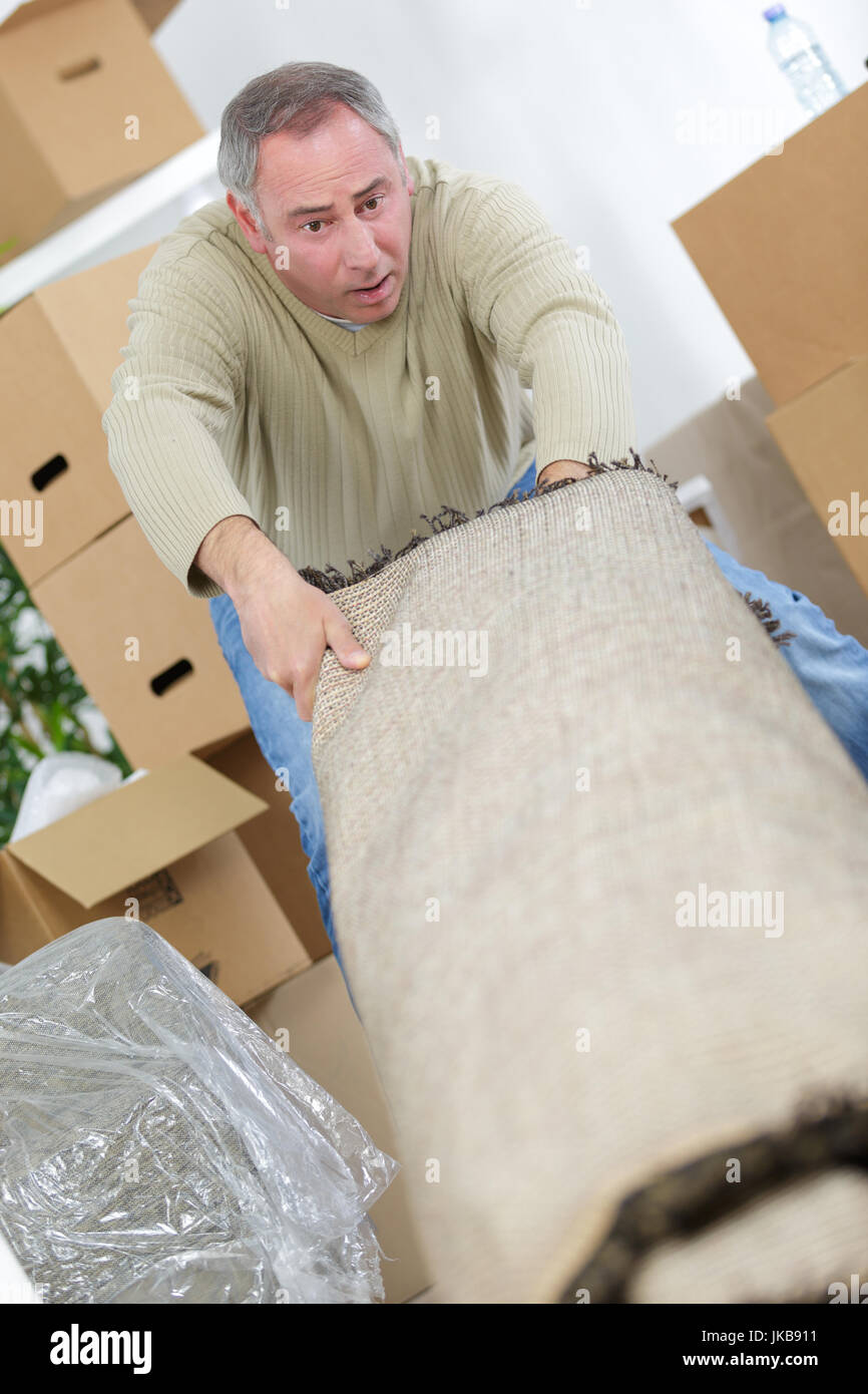 male worker folding carpet on floor at home Stock Photo Alamy
