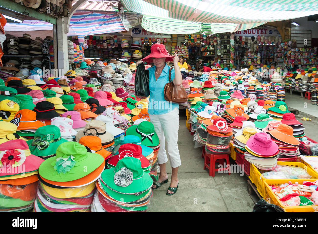 Tourist trying hat, Cholon market Ho Chi Minh City Saigon, Vietnam Stock Photo