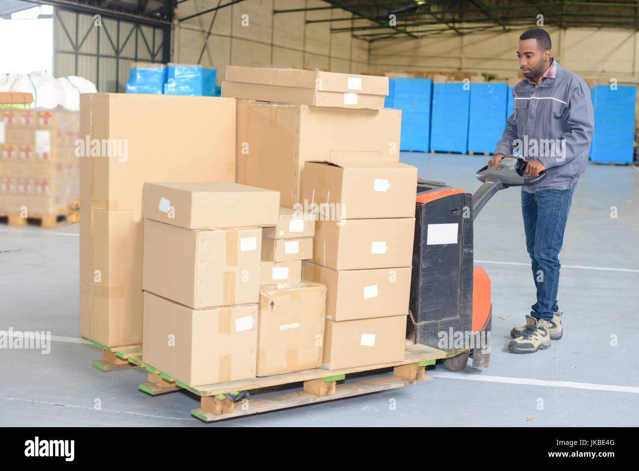 Download Worker Pushing Trolley With Boxes In Warehouse Stock Photo Alamy Yellowimages Mockups