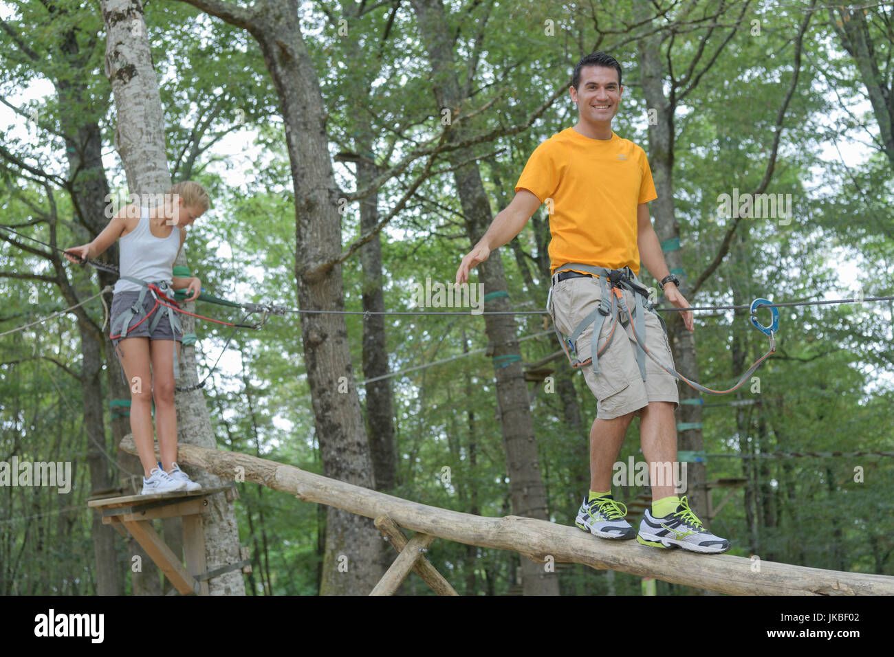 couple walking on suspended trunk at the adventure park Stock Photo