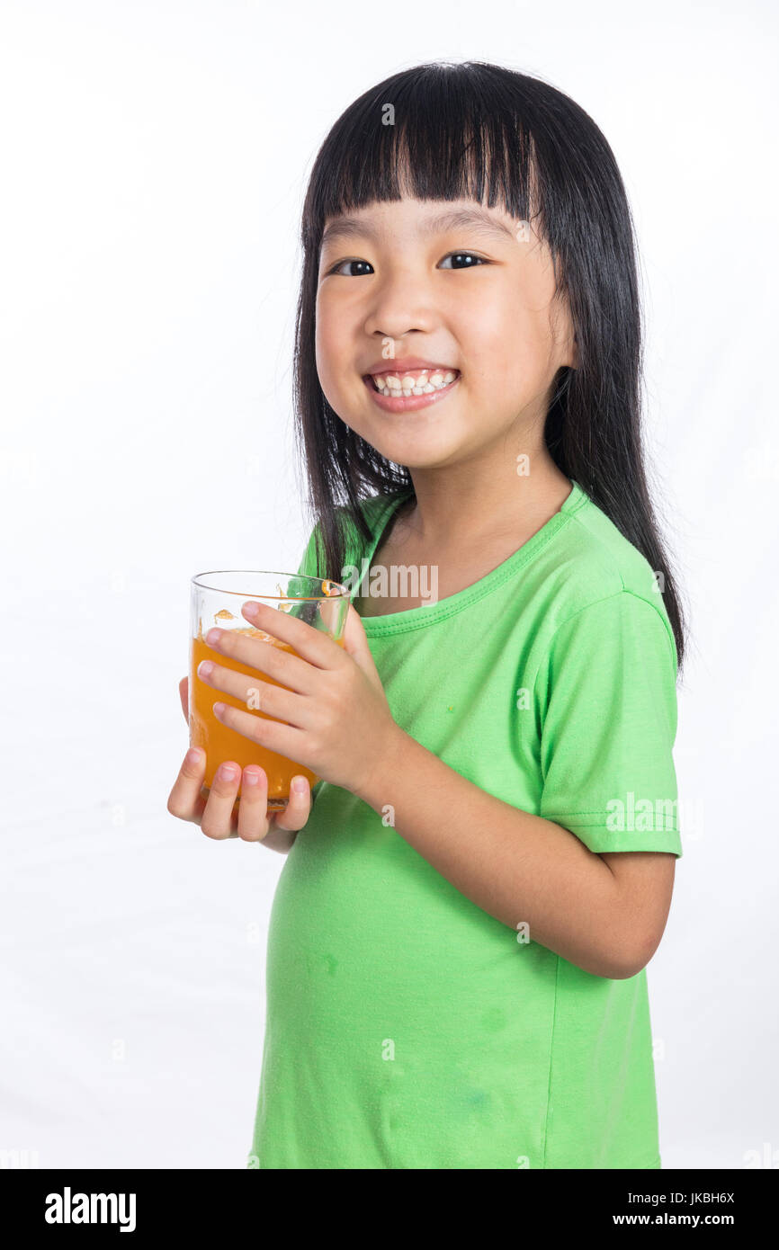 Happy Asian Chinese little girl drinking orange juice in isolated white ...