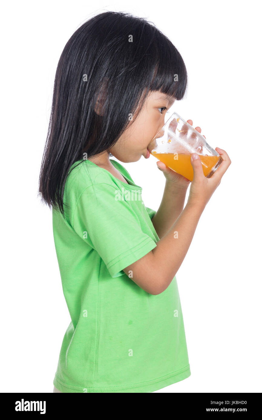 Happy Asian Chinese little girl drinking orange juice in isolated white ...