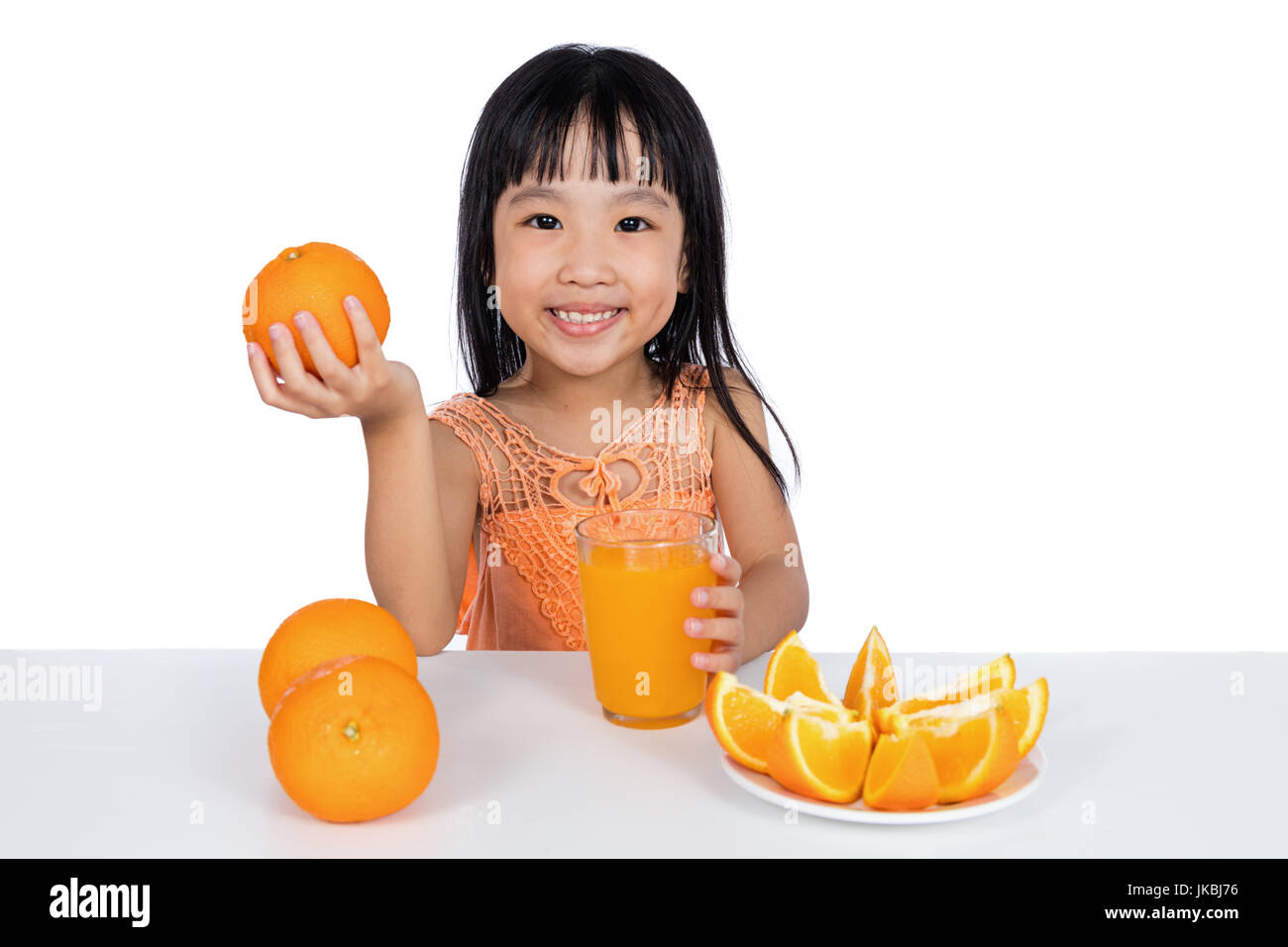 Happy Asian Chinese little girl drinking orange juice in isolated white ...
