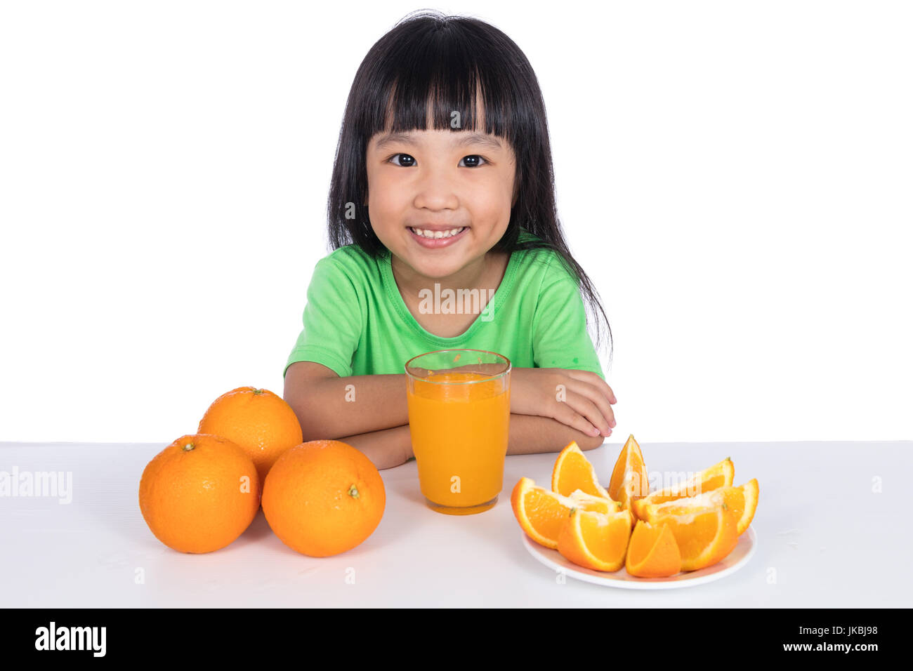 Happy Asian Chinese little girl drinking orange juice in isolated white ...