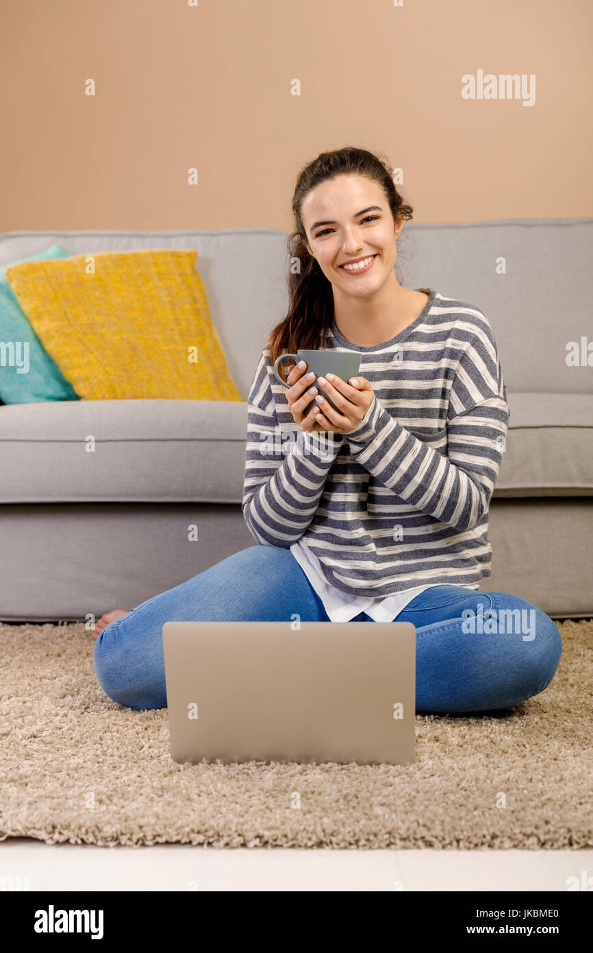 Beautiful woman at home working with a laptop and drinking coffee Stock ...