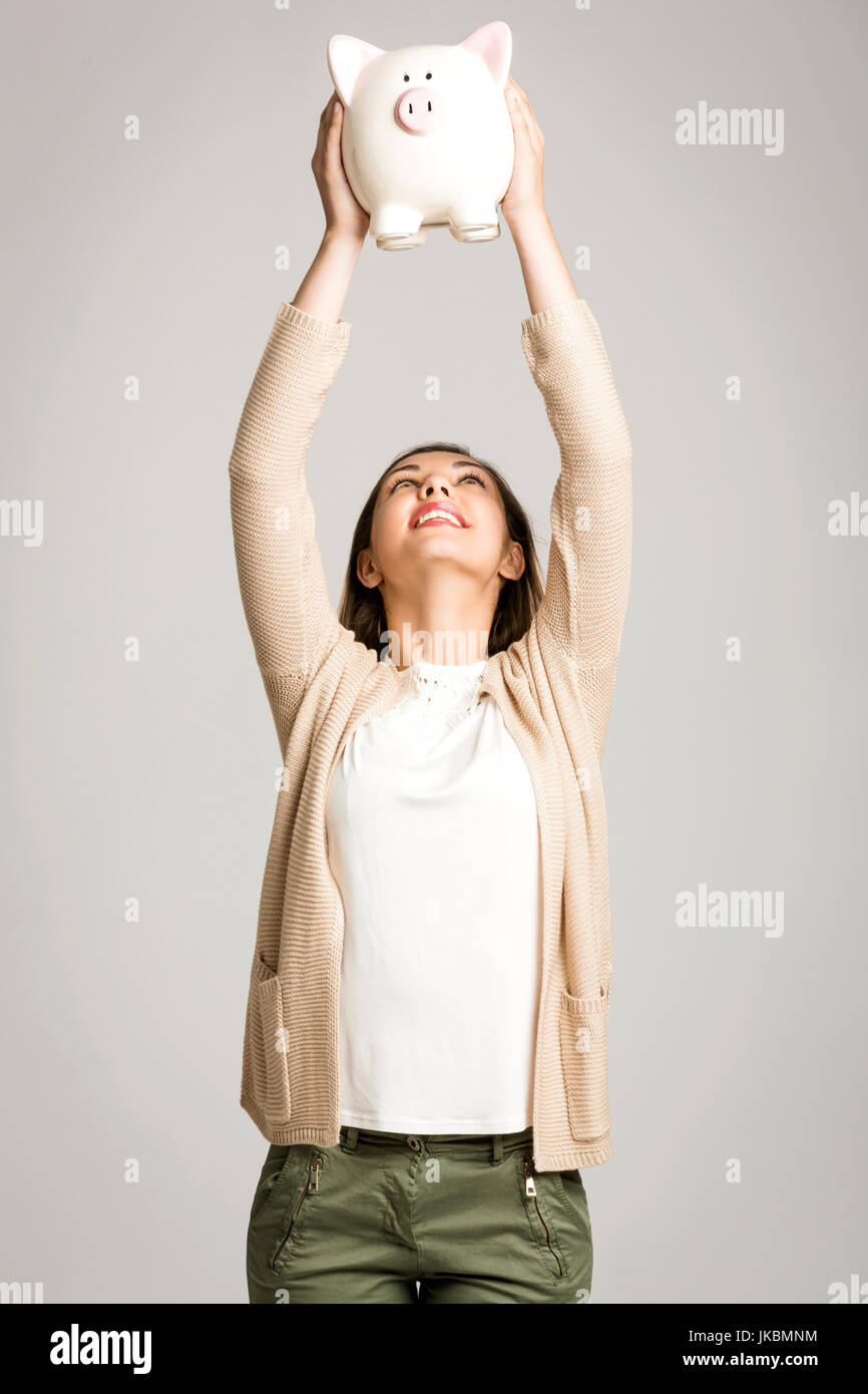 Beautiful and happy woman with arms high holding a piggy bank Stock ...