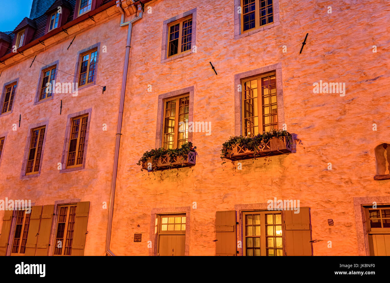 Quebec City, Canada - May 31, 2017: Colorful orange stone building closeup on street during twilight in lower old town Stock Photo