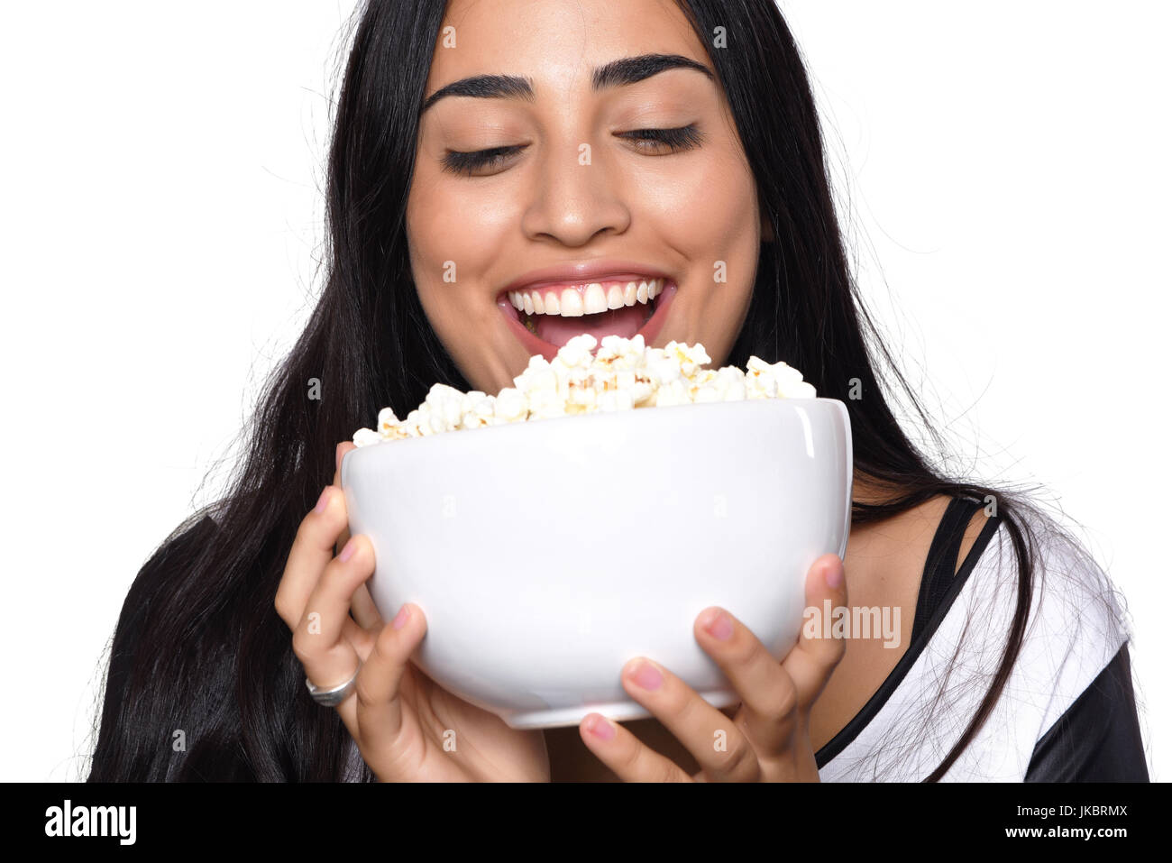 Young beautiful woman eating popcorn. Isolated white background Stock
