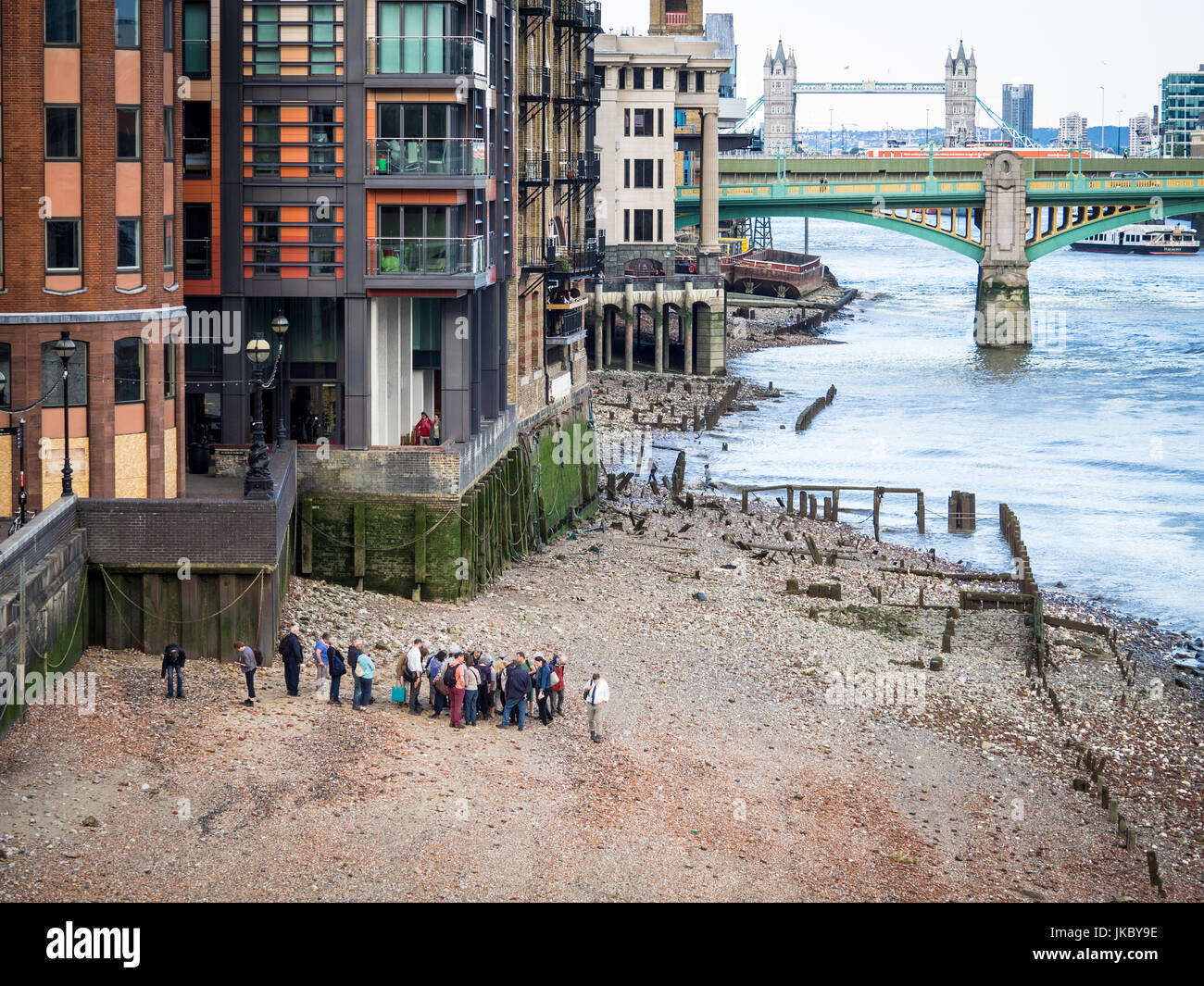 Thames Mudlarks and Tourists investigate the River Thames in London at low tide in the hope of finding historic artefacts Stock Photo