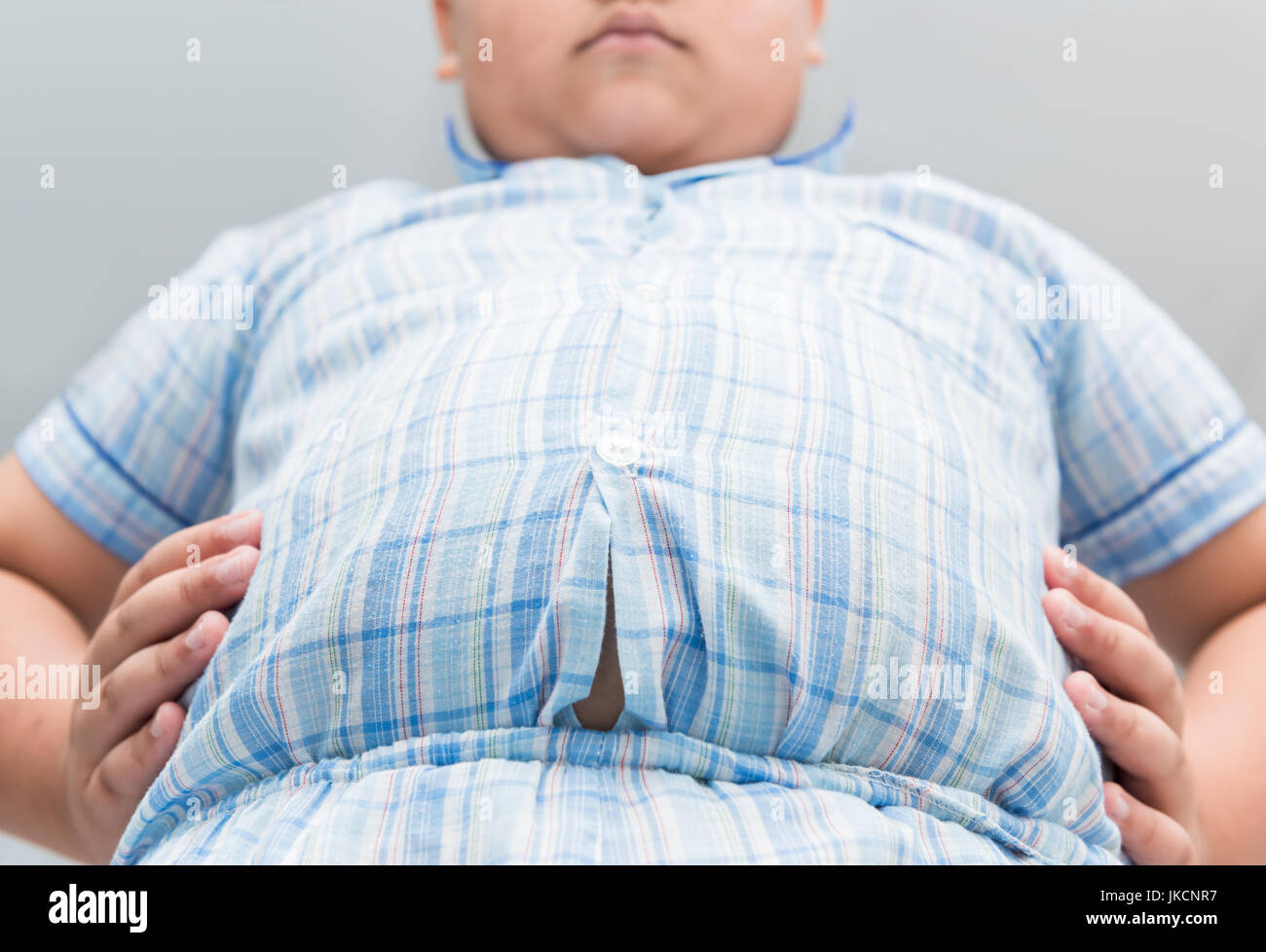 Obese fat boy overweight. Tight shirt of pajamas, healthy concept Stock Photo