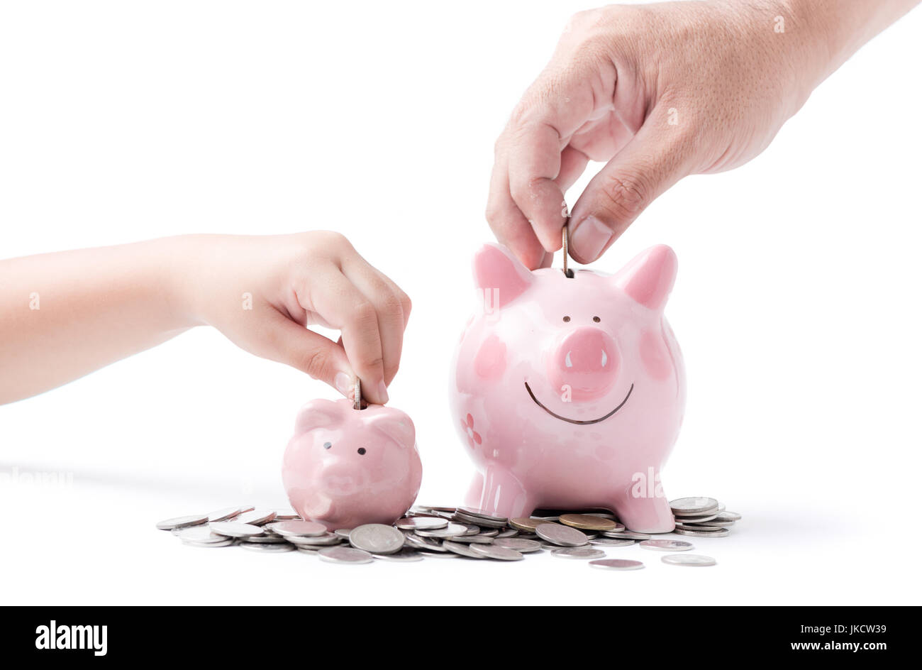 father and child hand put coin to piggy bank isolated on white ...