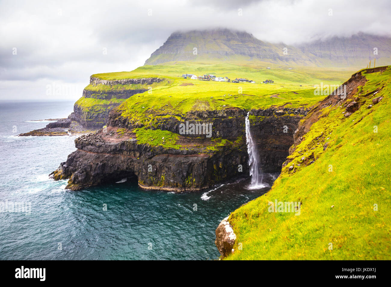 Dramatic waterfall on Faroe Islands and the village Gasadalur Stock Photo