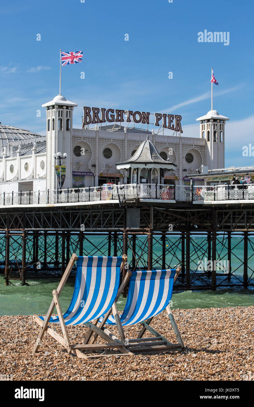 Two empty deck chairs overlooking Brighton Pier on the south coast of England. Stock Photo