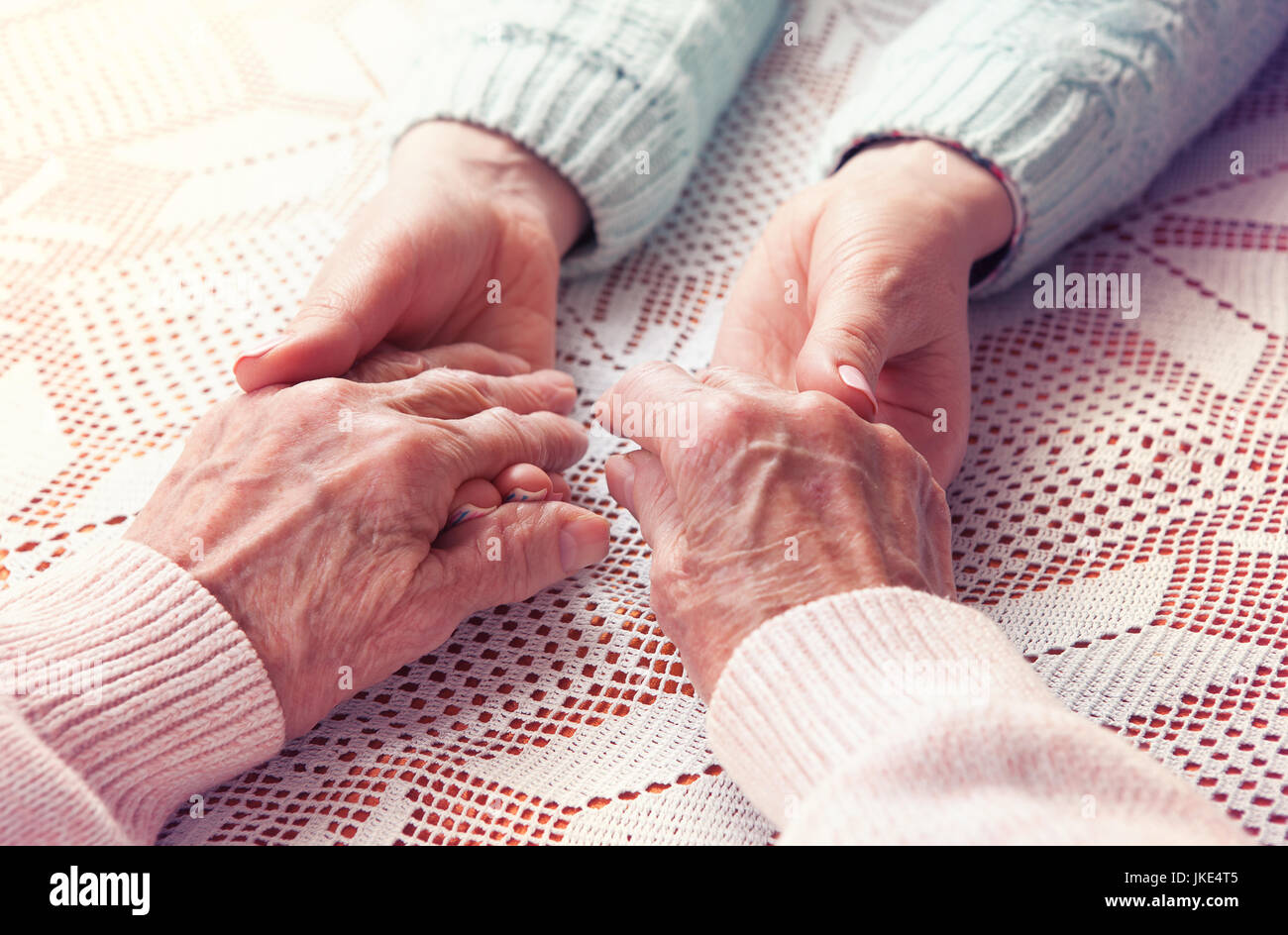 Care is at home of elderly. Senior woman with their caregiver at home. Concept of health care for elderly old people, disabled. Elderly woman. Space for text white background. Stock Photo