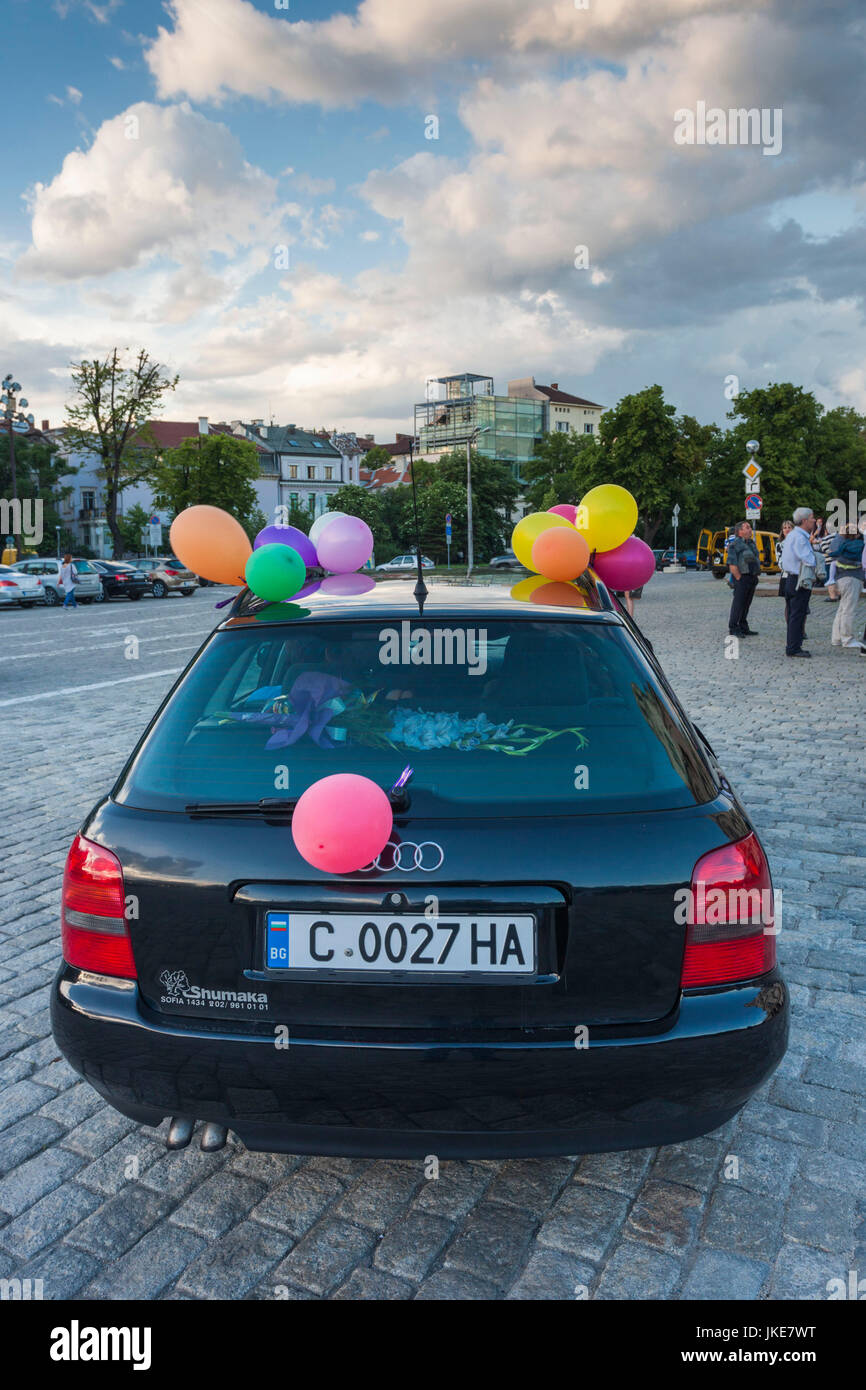 Bulgaria, Sofia, Ploshtad Alexander Nevski Square, Bulgarian students celebrating high school graduation, car with party balloons, NR Stock Photo