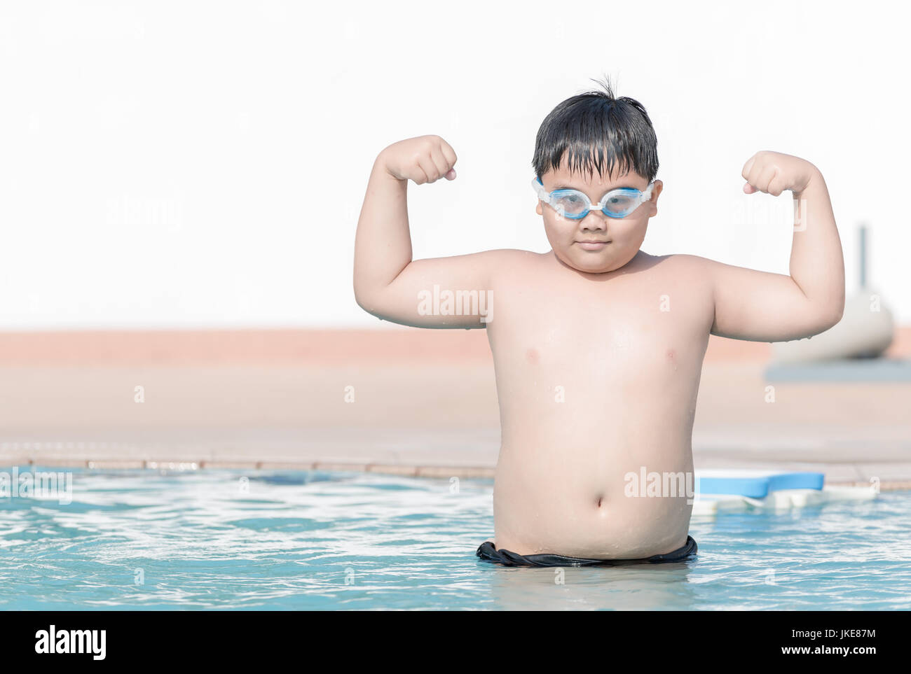 obese fat boy show muscle in swimming pool, concept healthy and