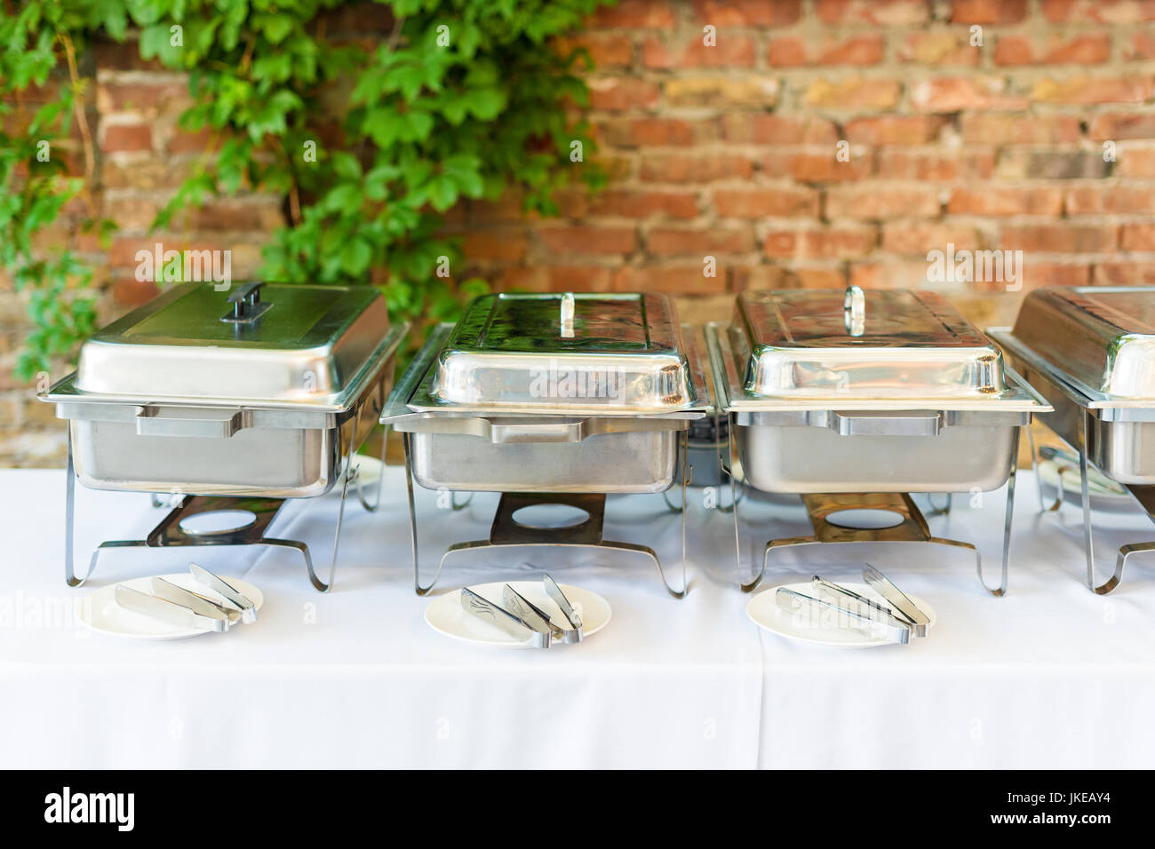 Buffet heated trays standing in line ready for service. Outdoors buffet
