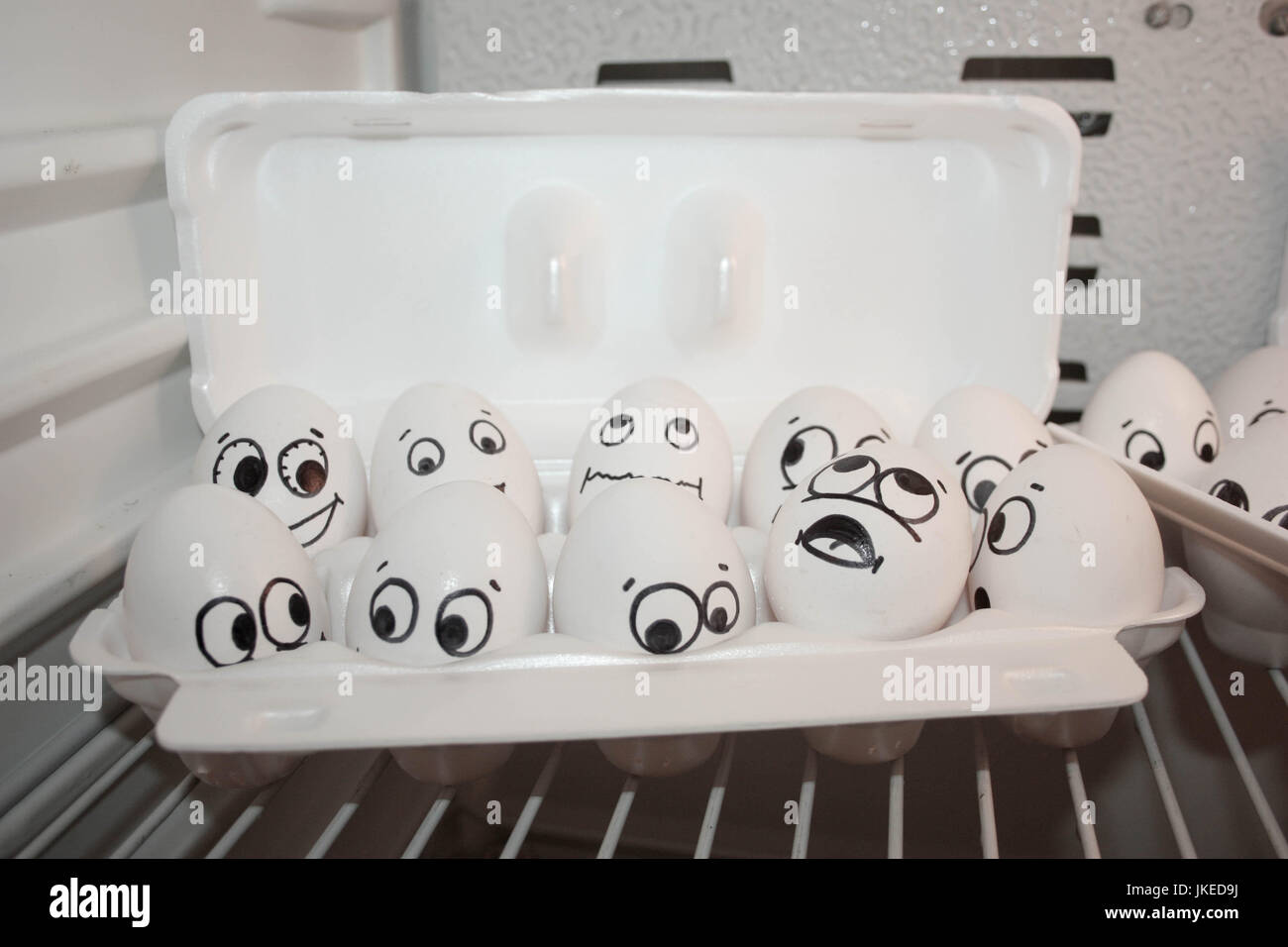 Concept of expectation. Face eggs are funny in the fridge. Photo for your design. Eggs in the container Stock Photo