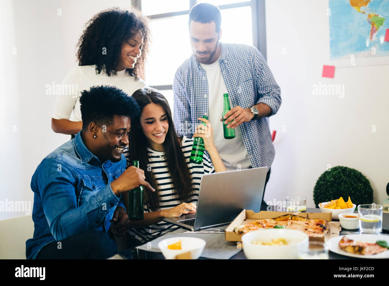 Friends at dining table sharing laptop Stock Photo - Alamy