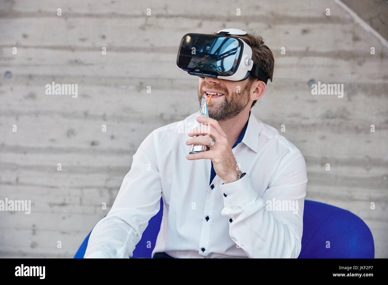 Man sitting on chair wearing VR glasses Stock Photo