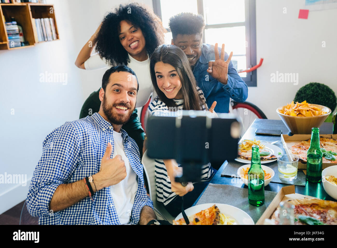 Group of friends posing for a selfie at dining table at home Stock ...