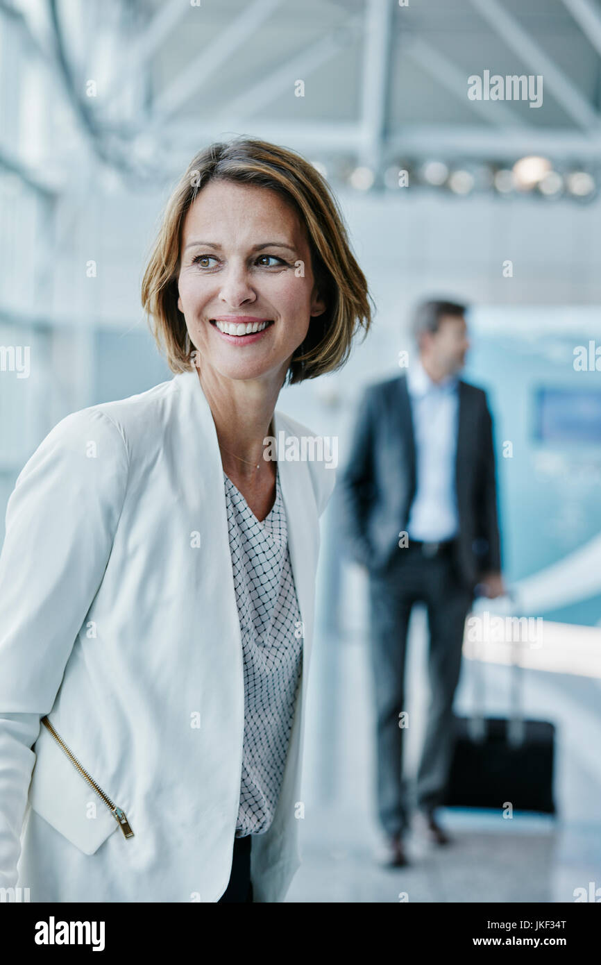 Smiling businesswoman at the airport looking sideways Stock Photo