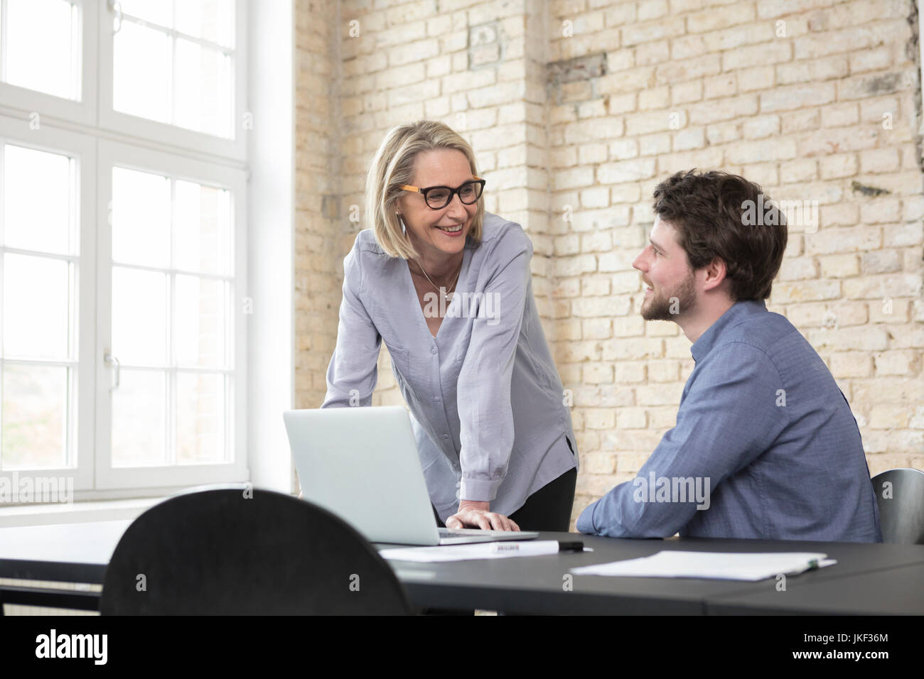 Mature businesswoman working with younger colleague in office Stock Photo