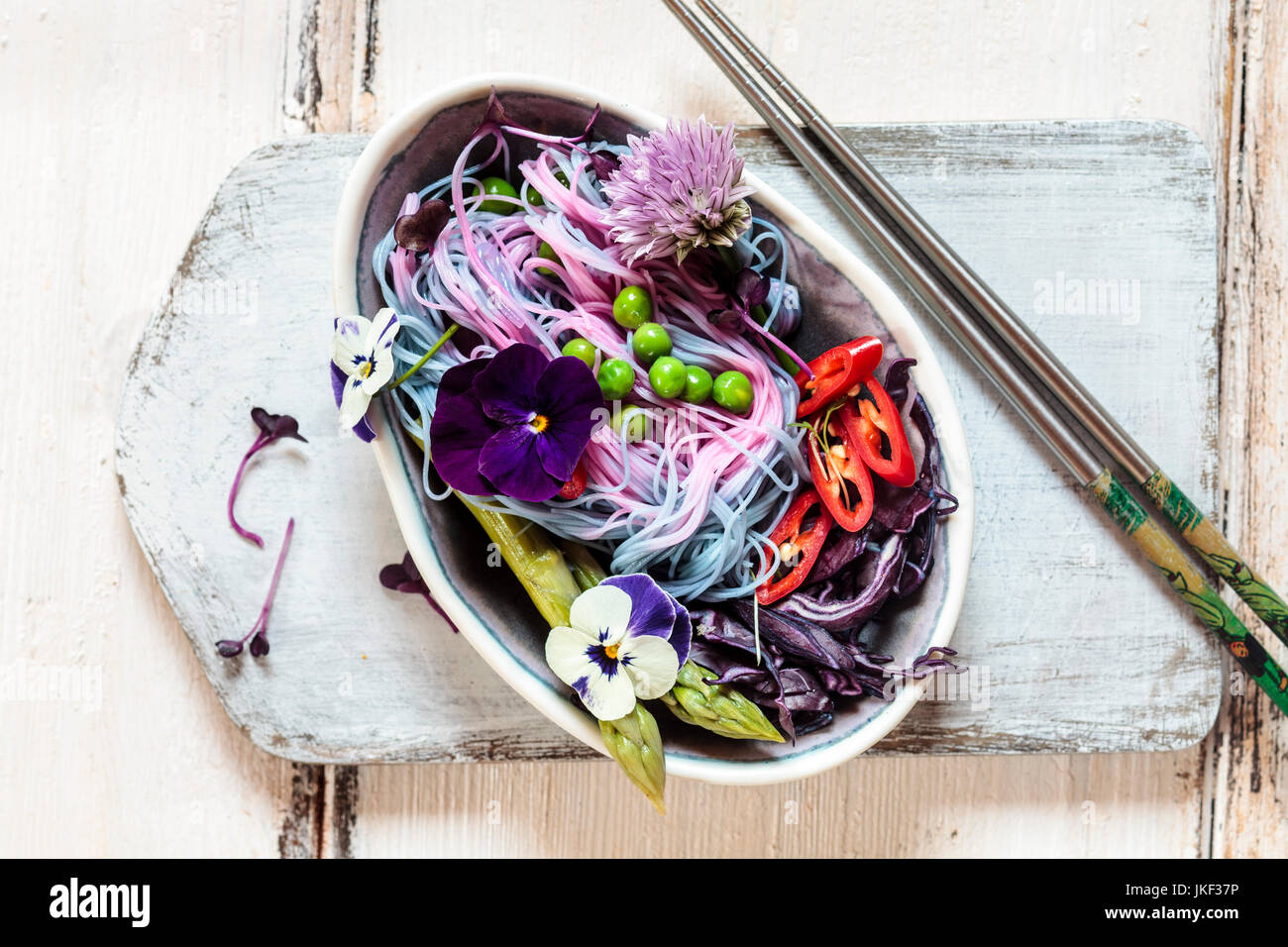 Vegan Unicorn Noodles, edible flowers, red cabbage, asparagus, peas, chili, sprouts Stock Photo