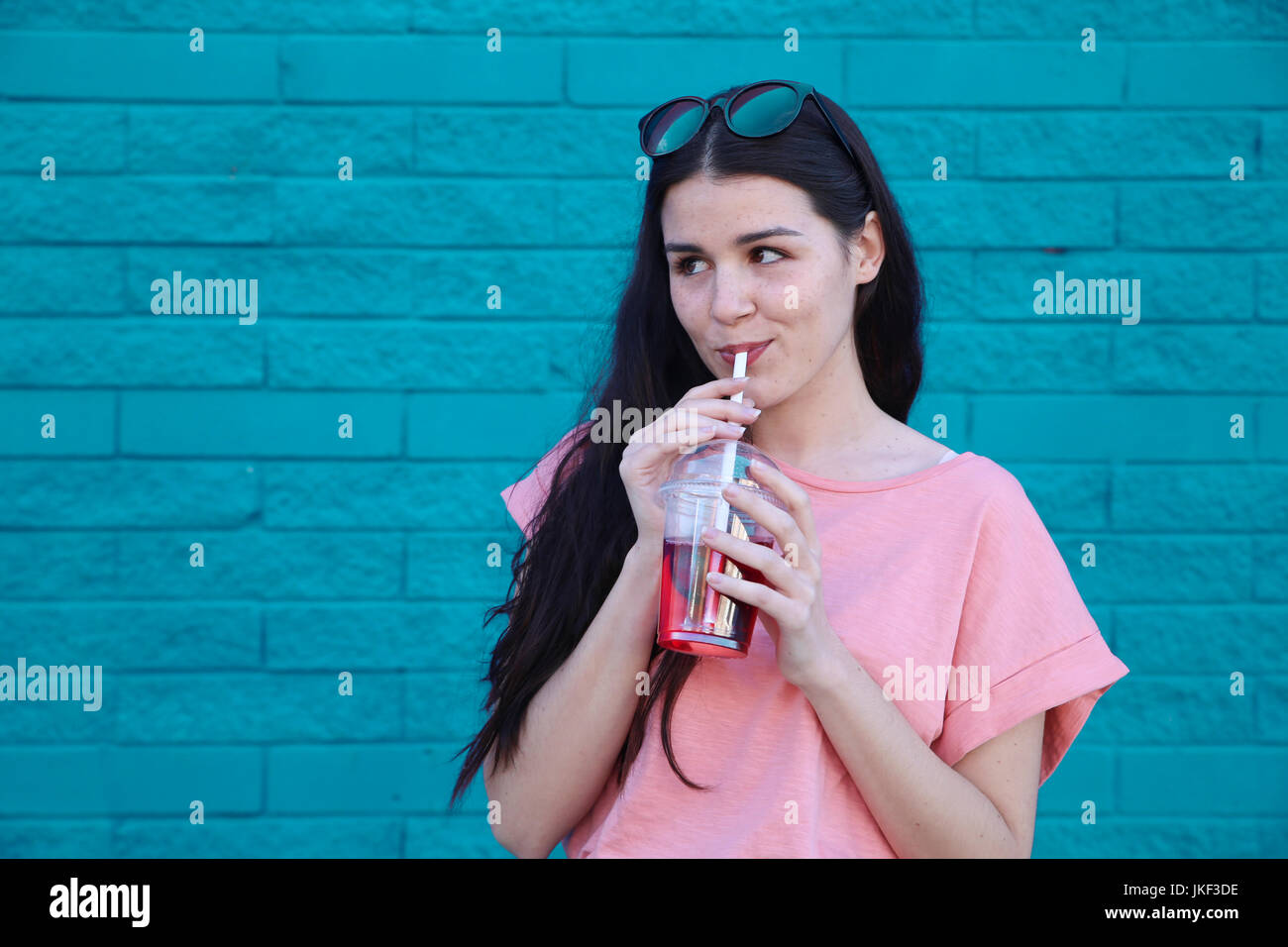 Portrait of young woman drinking soft drink Stock Photo