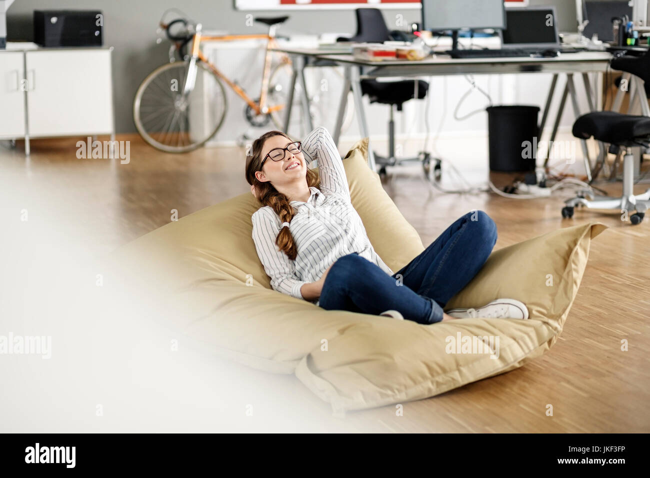 Young woman relaxing in bean bag in office Stock Photo - Alamy
